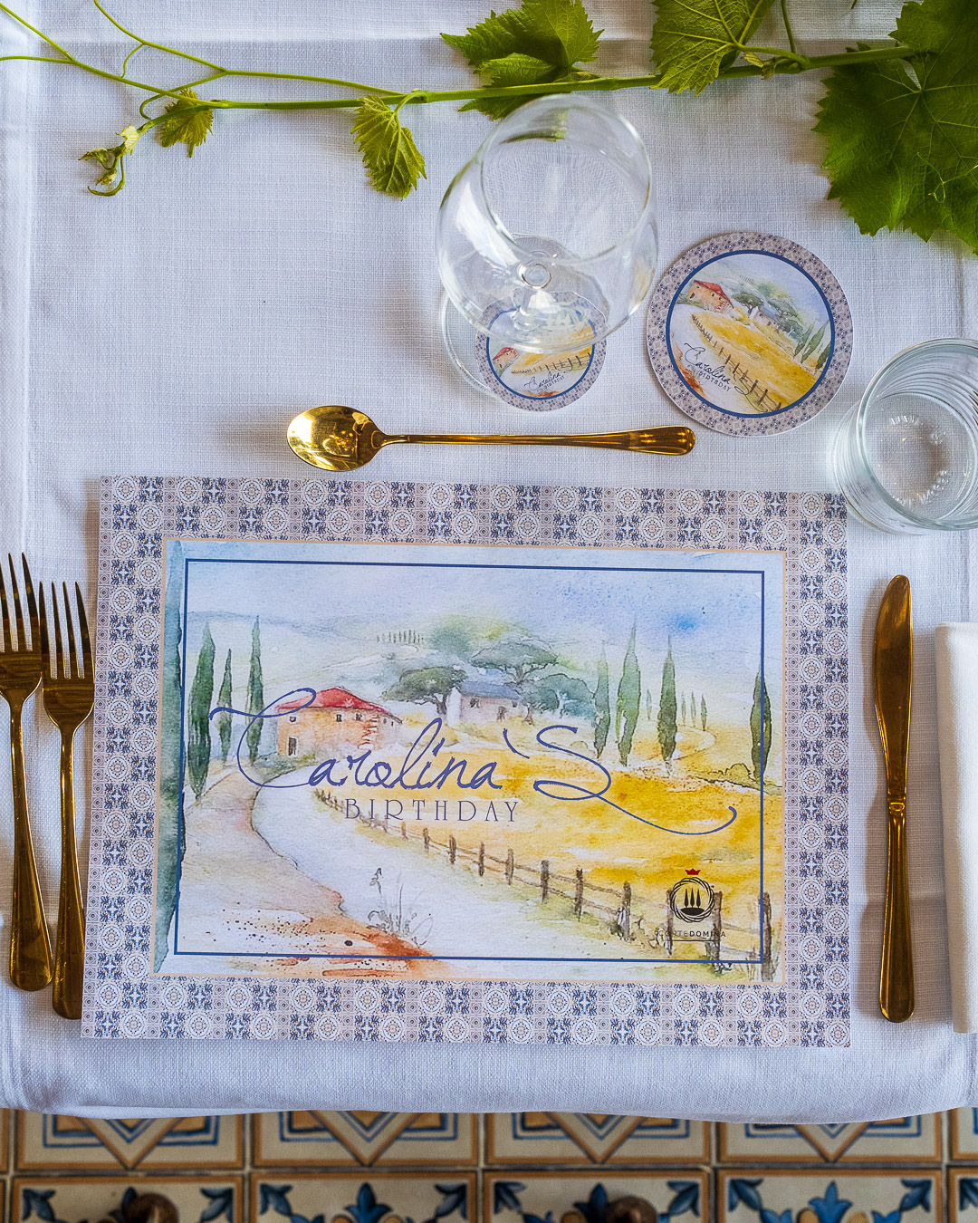 Elegante mesa decorada con motivos vegetales, cubertería dorada y manteles individuales con motivos artísticos. Elegante mesa decorada con motivos vegetales, cubertería dorada y manteles individuales con motivos artísticos.