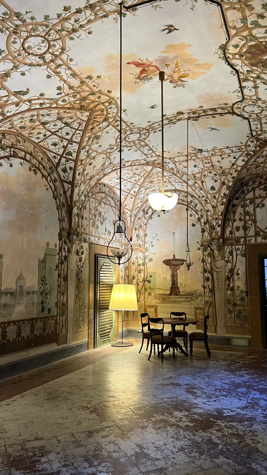 Sala ornamentada con frescos que representan enredaderas y pájaros en techos abovedados.