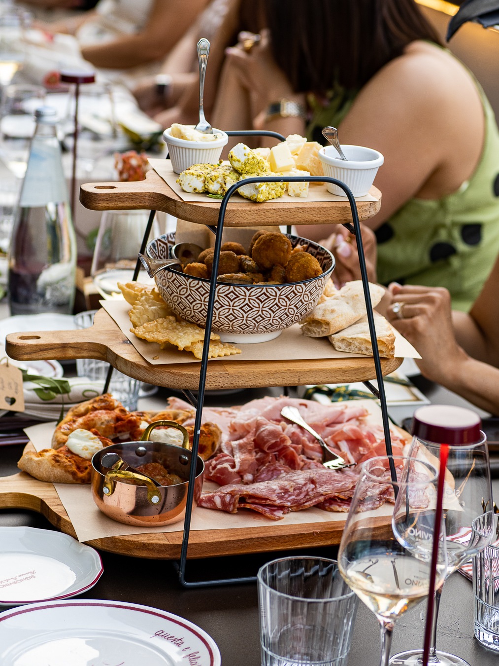 Aperitivo privado con productos italianos Aperitivo italiano servido en bandejas de madera con quesos, embutidos, focaccia y fritos, junto a copas de vino blanco