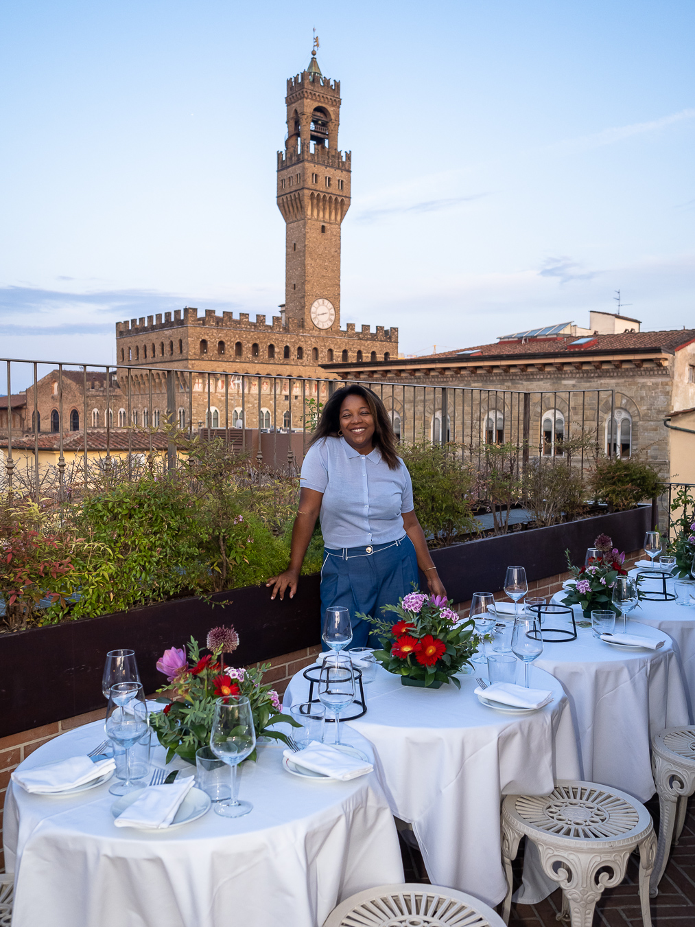 Layli Reyes en una terraza con mesas preparadas frente al Palazzo Vecchio de Florencia