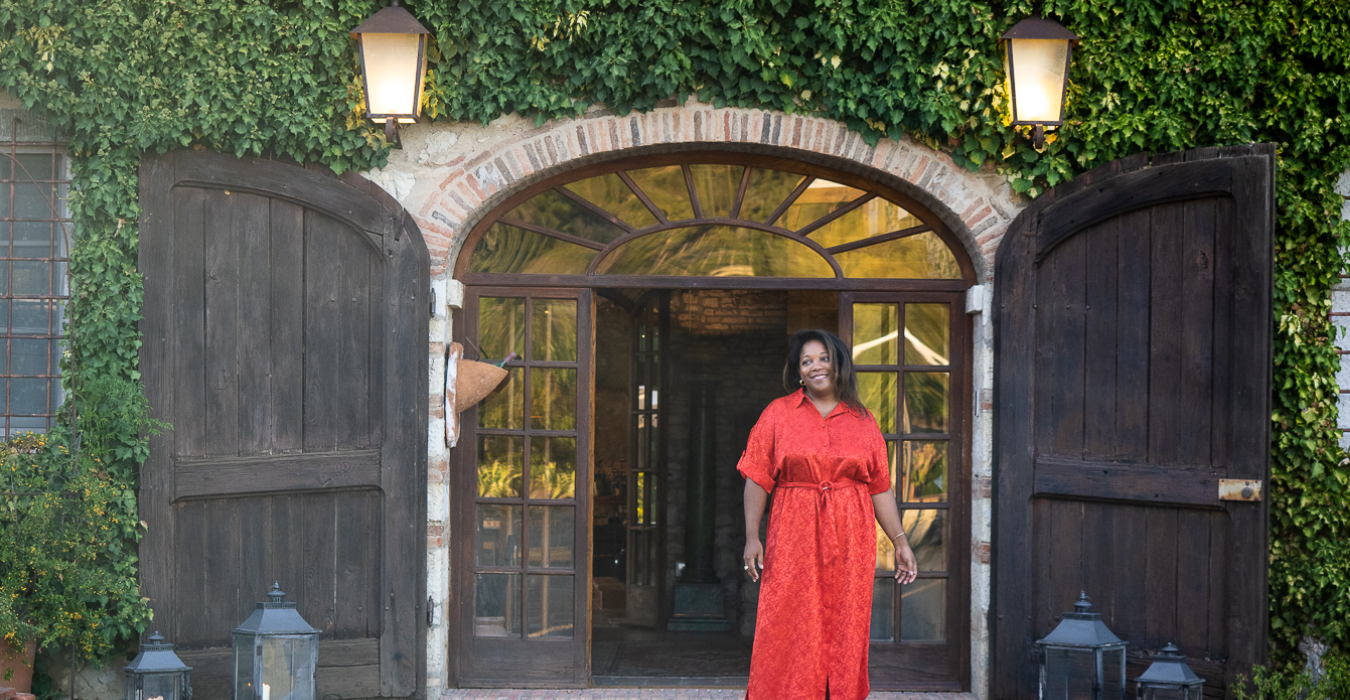 Layli con vestido rojo en la entrada de una villa toscana
