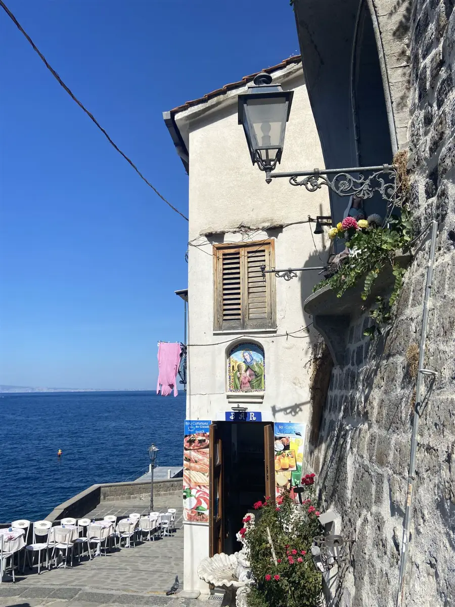 Calle junto al mar con balcón florido y terraza en Sorrento