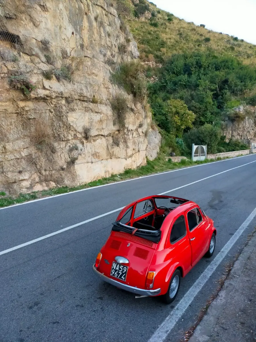 Fiat 500 rojo descapotable en una carretera de la Costa Amalfitana