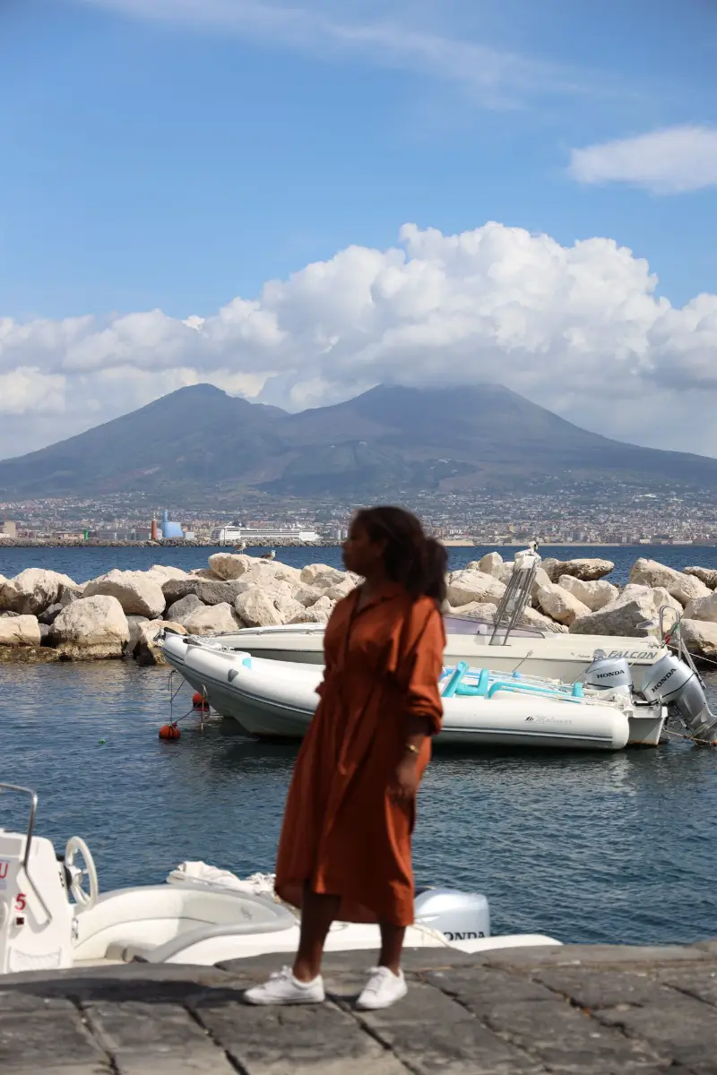 Viajera frente al puerto de Nápoles con el Vesubio al fondo