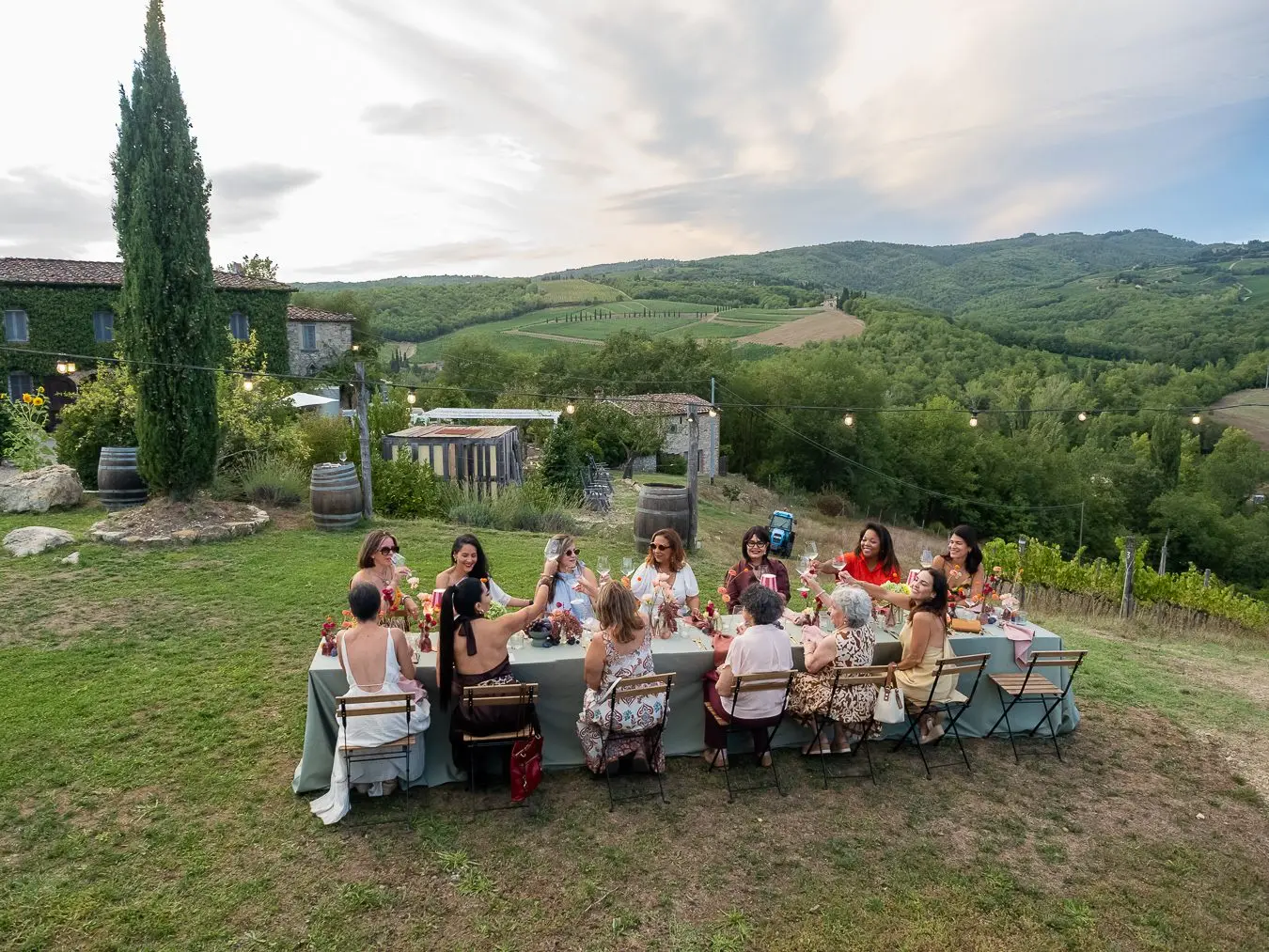 Viajeras compartiendo una mesa larga en la campiña toscana