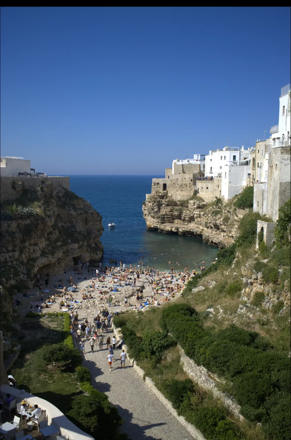 Playa de Lama Monachile entre acantilados y casas blancas en Polignano a Mare, Puglia